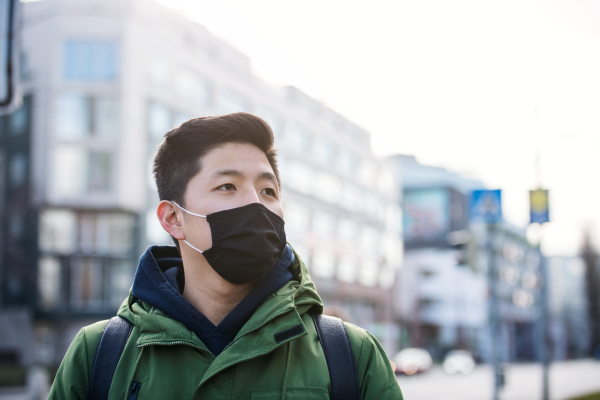 Man wearing face mask in city, coronavirus prevention and protection concept. Copy space.