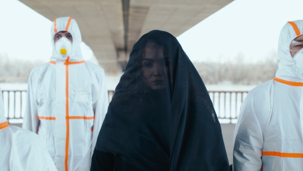 People with protective suits and respirators outdoors, coronavirus and death concept.