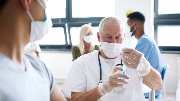 Senior doctor and people getting vaccinated, coronavirus, covid-19 and vaccination concept.