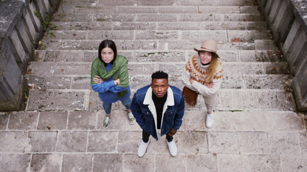 Top view portrait of group of young people outdoors in town, looking at camera.