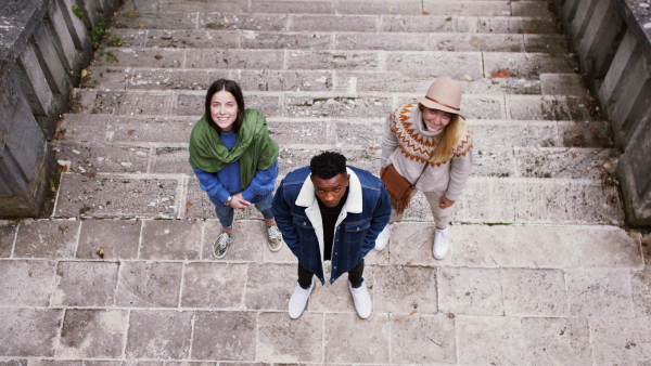 Top view portrait of group of young people outdoors in town, looking at camera.