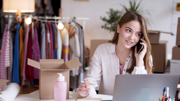 Young woman dropshipper with laptop working at home, coronavirus concept.