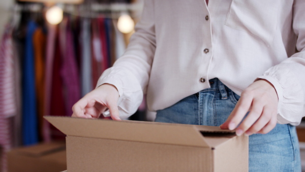 Unrecognizable young woman dropshipper working at home, coronavirus concept.