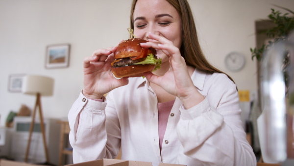 Front view of young woman with tablet ordering food at home, coronavirus and food delivery concept.