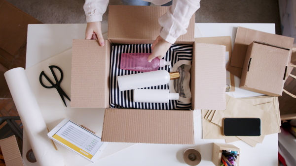 Top view of unrecognizable young woman dropshipper with tablet working at home, coronavirus concept.