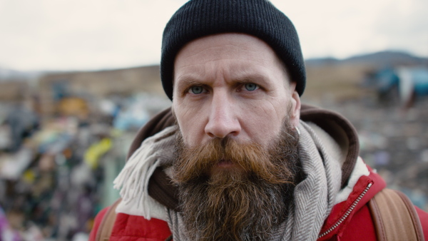 Close-up portrait of man activist on landfill, environmental pollution concept. Slow motion.