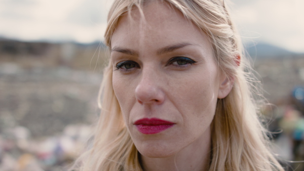 Close-up portrait of woman activist standing on landfill, environmental pollution concept. Slow motion.