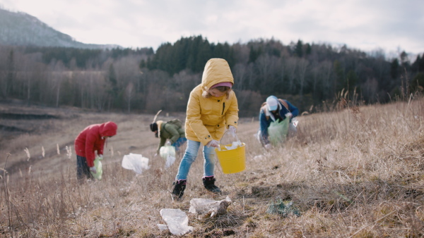 Group of activists picking up litter in nature, environmental pollution and plogging concept.