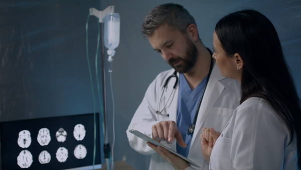 Doctors with tablet talking in hospital, coronavirus concept.