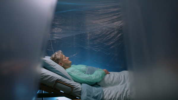 Senior infected patient in quarantine lying in bed in hospital, coronavirus concept.