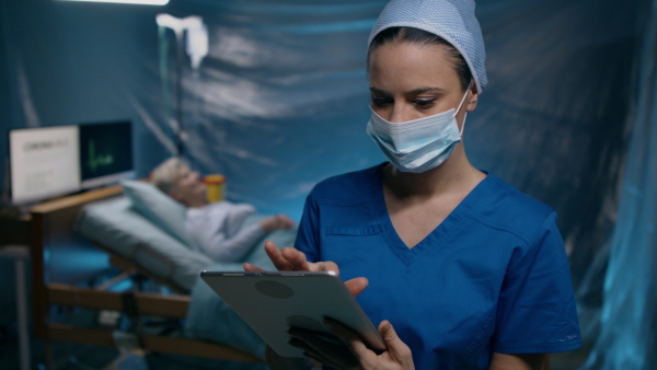 Woman doctor holding tablet in hospital, coronavirus concept.