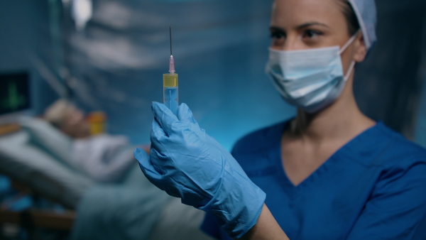 Woman doctor holding syringe in hospital, coronavirus concept.