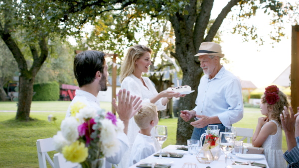 Large family having a big garden party and celebrating grandfathers birthday.