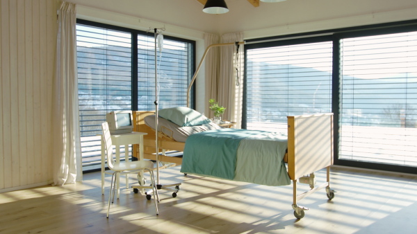 An empty, adjustable bed in room in private modern hospital.