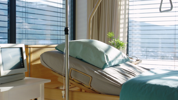 An empty, adjustable bed in room in private modern hospital.