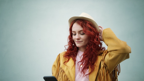 A young woman tourist outdoors against white background on trip in town, taking selfie.