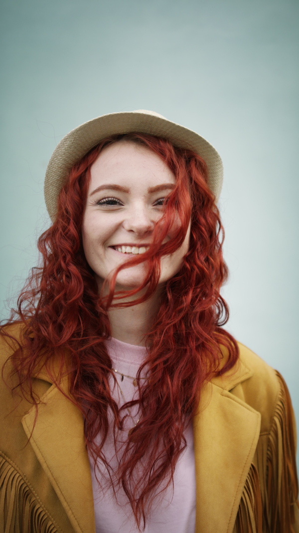 A vertical footage of young woman tourist outdoors against white background on trip in town, looking at camera.