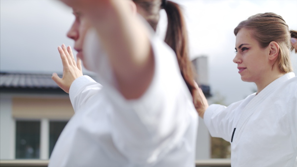 A group of young women practising karate outdoors on terrace.