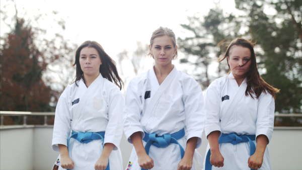 A group of young women practising karate outdoors on terrace.