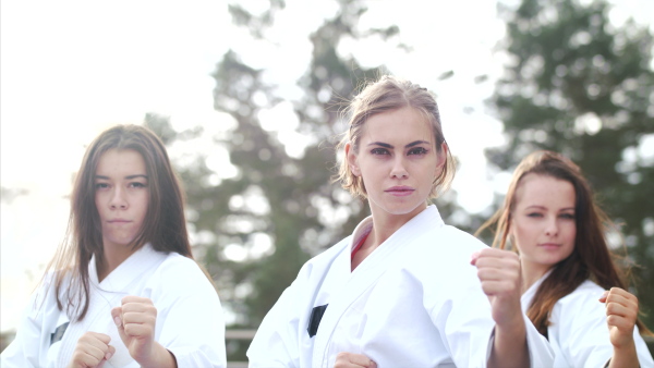 A group of young women practising karate outdoors on terrace.