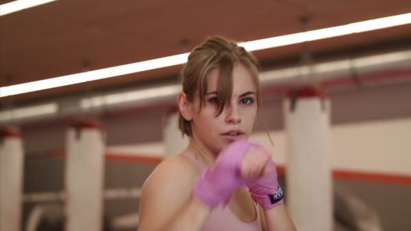 An attractive young woman practising karate indoors in gym. Copy space.