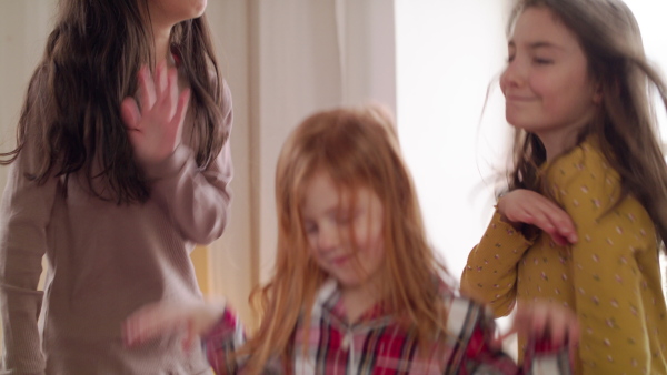 A group of small girls friends jumping on bed on slumber party. Slow motion.