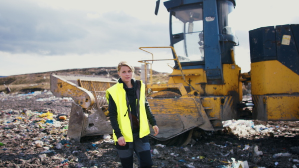 Front view of woman worker on landfill, waste management and environmental concept.