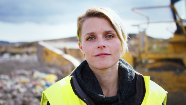 Front view of woman worker on landfill, waste management and environmental concept.