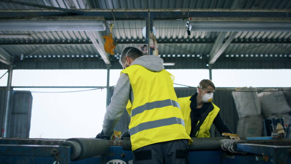 Man and woman workers with face maks working on landfill, waste management and environmental concept.