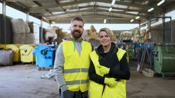 Man and woman workers working on landfill, waste management and environmental concept.