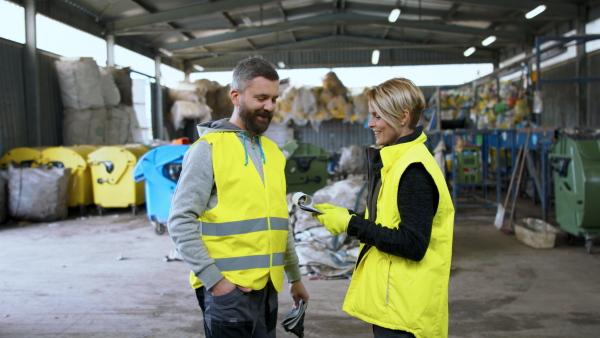 Man and woman workers working on landfill, waste management and environmental concept.