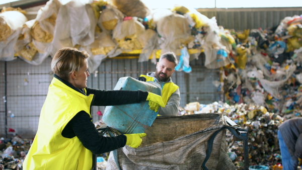 Man and woman workers working on landfill, waste management and environmental concept.