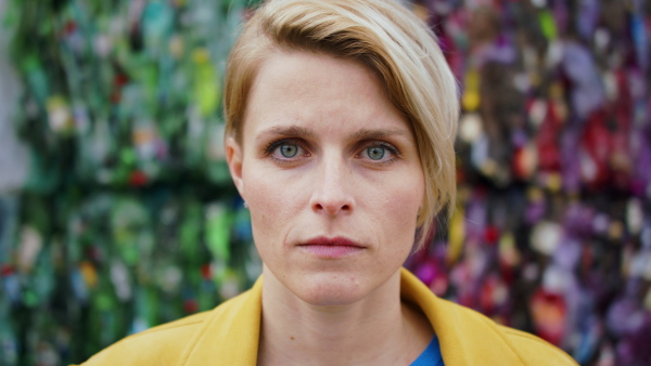 Front view portrait of woman standing and looking at camera on landfill, waste management and environmental concept.