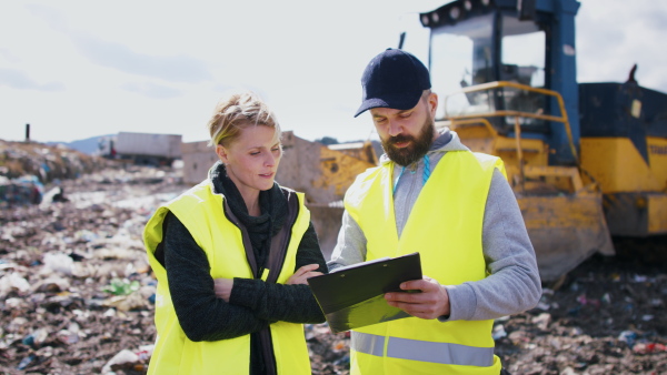 Man and woman workers working on landfill, waste management and environmental concept.