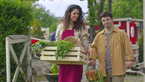 A group of community farmers walking towards camera with box of vegetables. Community farming concept.