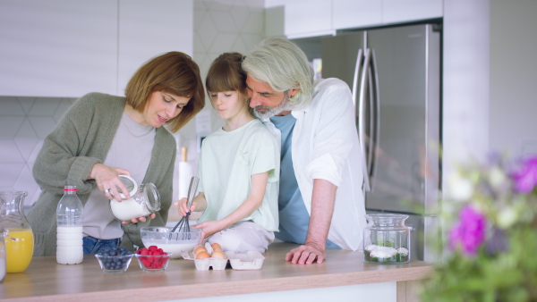 A beautiful family at home preparing a pancake mix together.