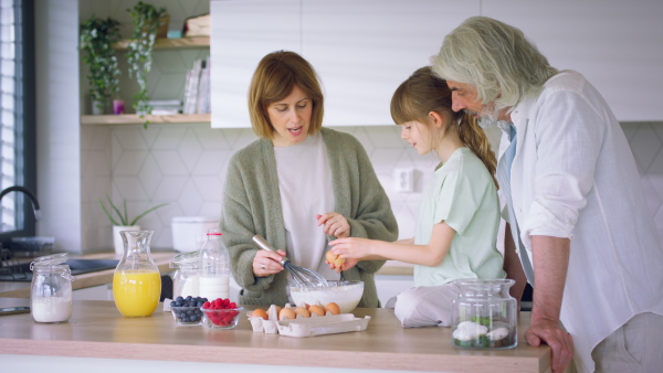 A beautiful family at home preparing a pancake mix together.