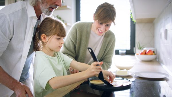 A beautiful family at home making a pancakes together.