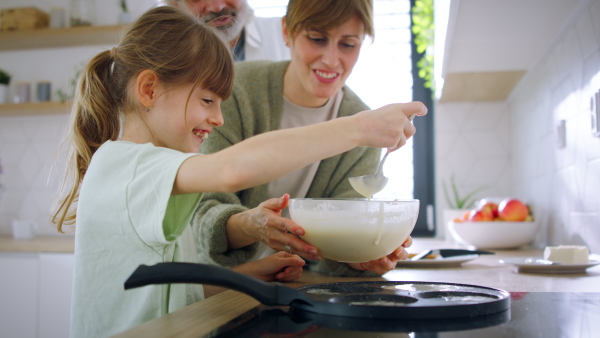 A beautiful family at home making a pancakes together.