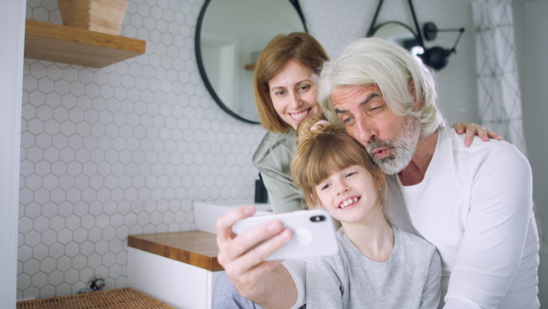 A beautiful family taking selfie in the bathroom.