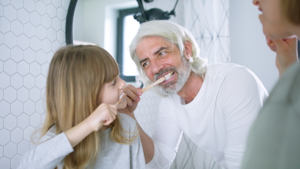 Happy family tooth brushing teeth together in the morning, getting ready for day.