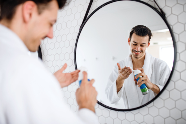 A young man shaving in the bathroom in the morning, a daily routine.