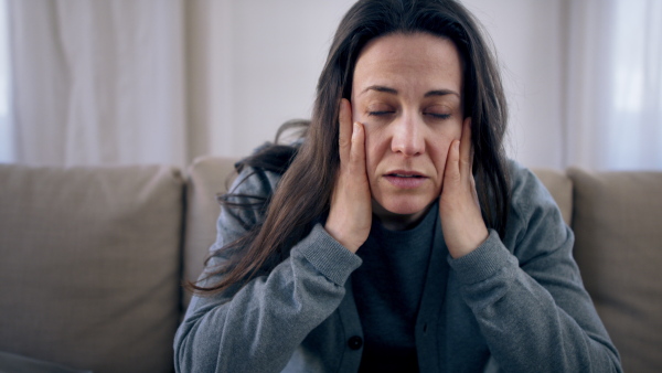 Front view of sad and depressed woman indoors, mental health concept. Slow motion.