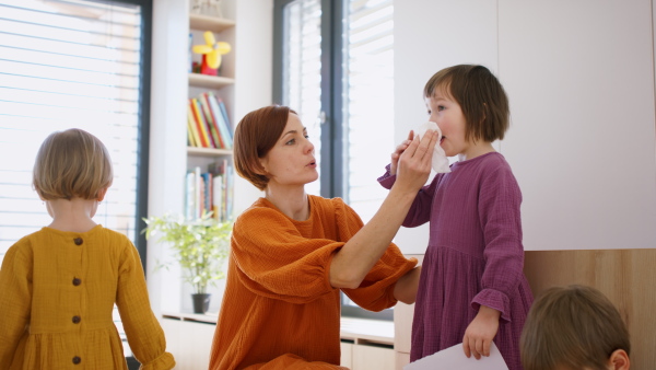 Mother with small children in bedroom in the morning at home, everyday life concept.