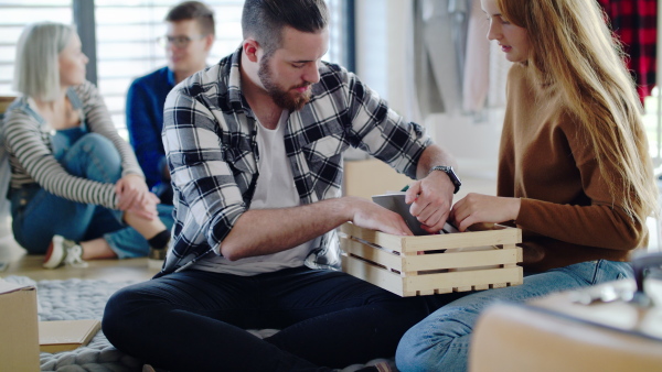 Group of cheerful young people moving in new home, house sharing concept.