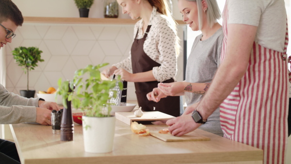 Group of young people cooking together at home, house sharing concept.