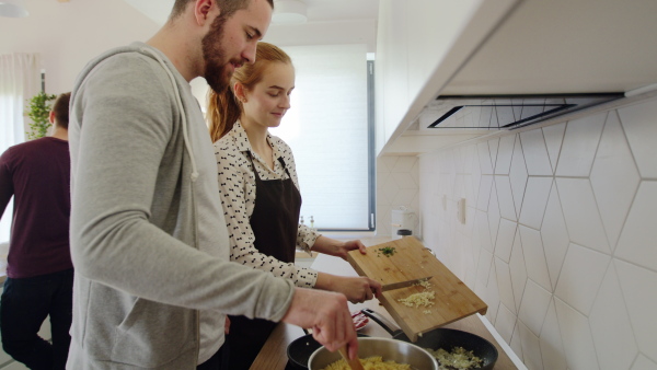 Group of young people cooking together at home, house sharing concept.