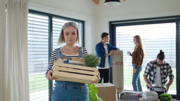 Group of cheerful young people moving in new home, house sharing concept.