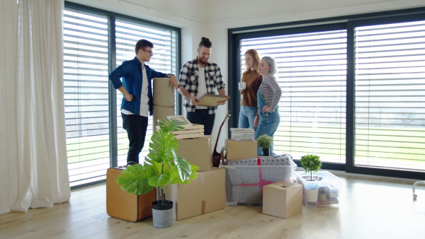 Group of cheerful young people moving in new home, house sharing concept.