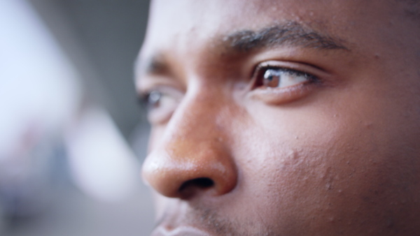 Extreme close-up of frustrated young black man outdoors, black lives matter concept.